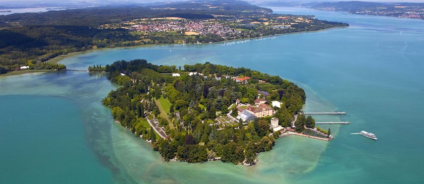 Die malerische Insel Mainau im klaren Wasser, umgeben von grüner Natur und einem charmanten Ufer.