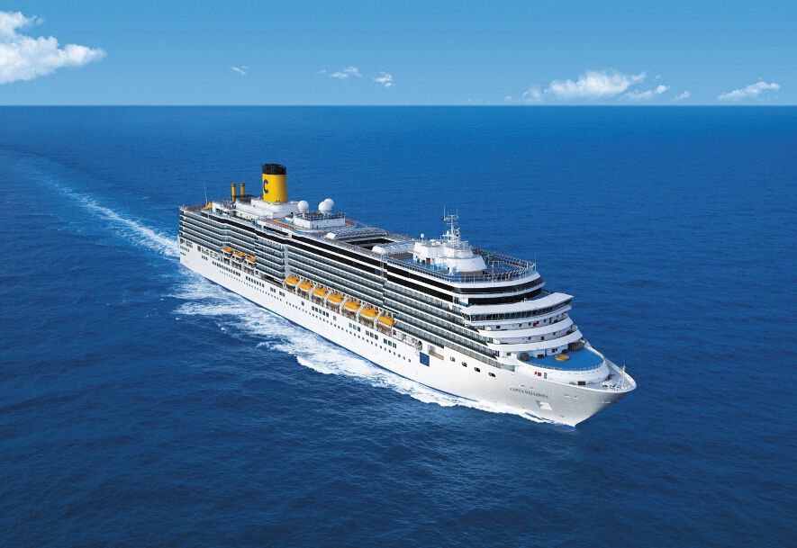 Ein großes Kreuzfahrtschiff fährt durch das blaue Meer unter einem klaren Himmel.
