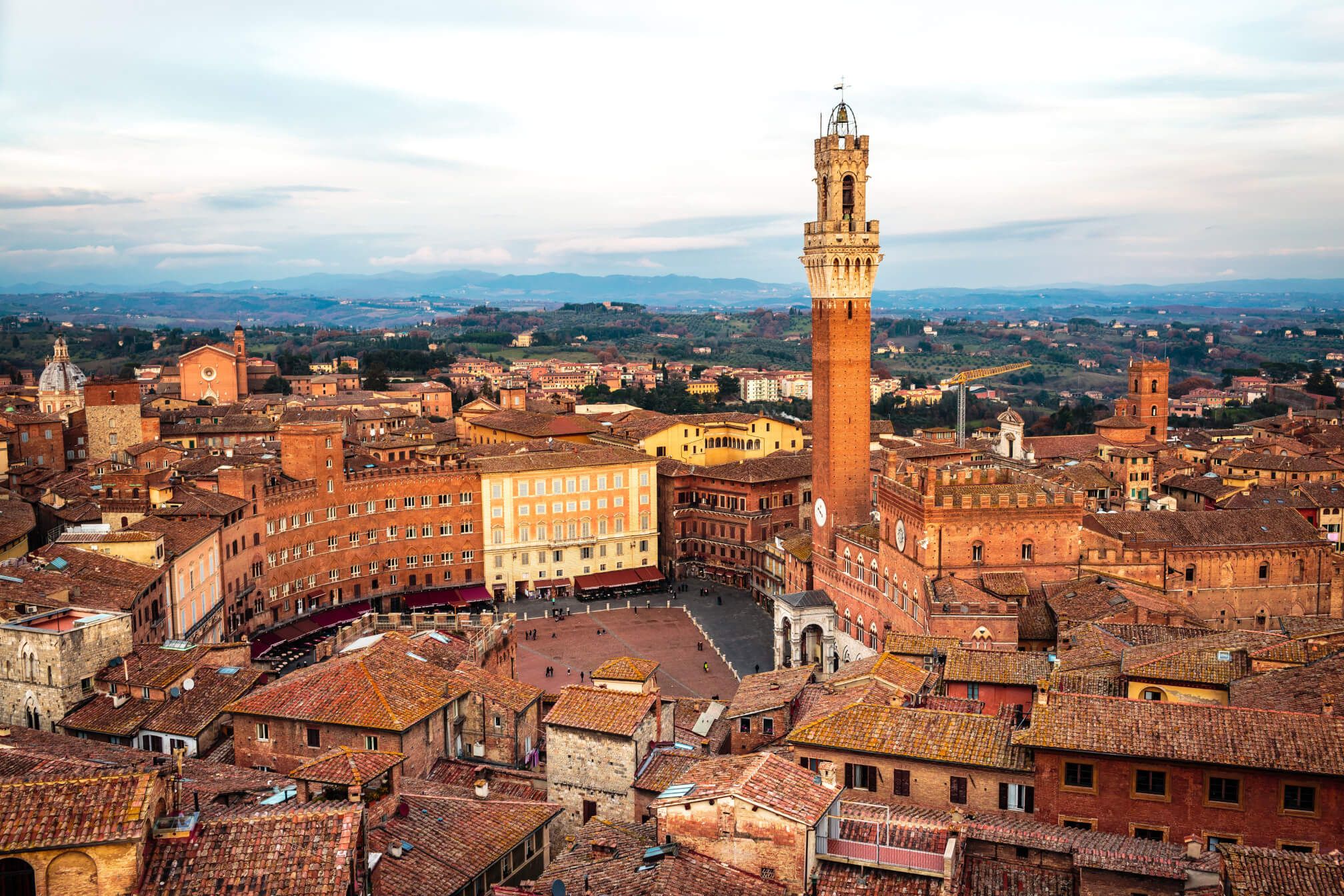 Ein Blick auf Siena mit dem beeindruckenden Torre del Mangia und den charakteristischen roten Dächern der Stadt.