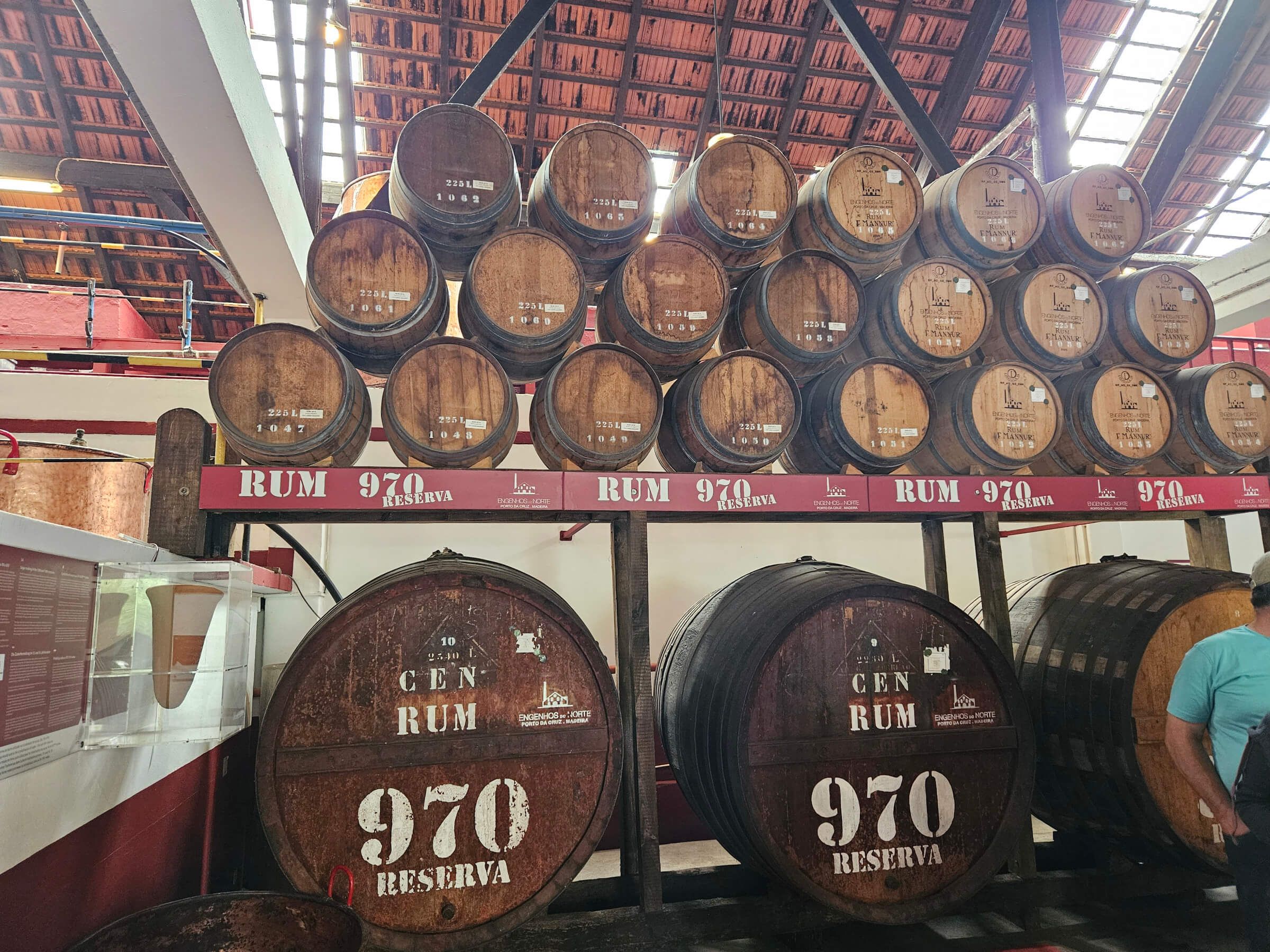 Holzfässer für Rum lagern in einer rumproduzierenden Anlage, beschriftet mit „970 RESERVA“.