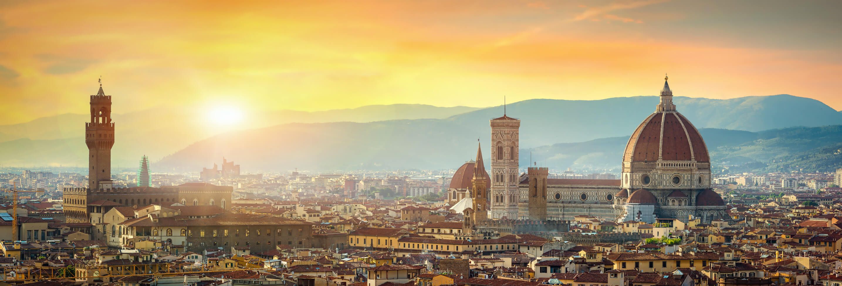 Florenz bei Sonnenuntergang, mit der beeindruckenden Kathedrale und umliegenden Hügeln im Hintergrund.
