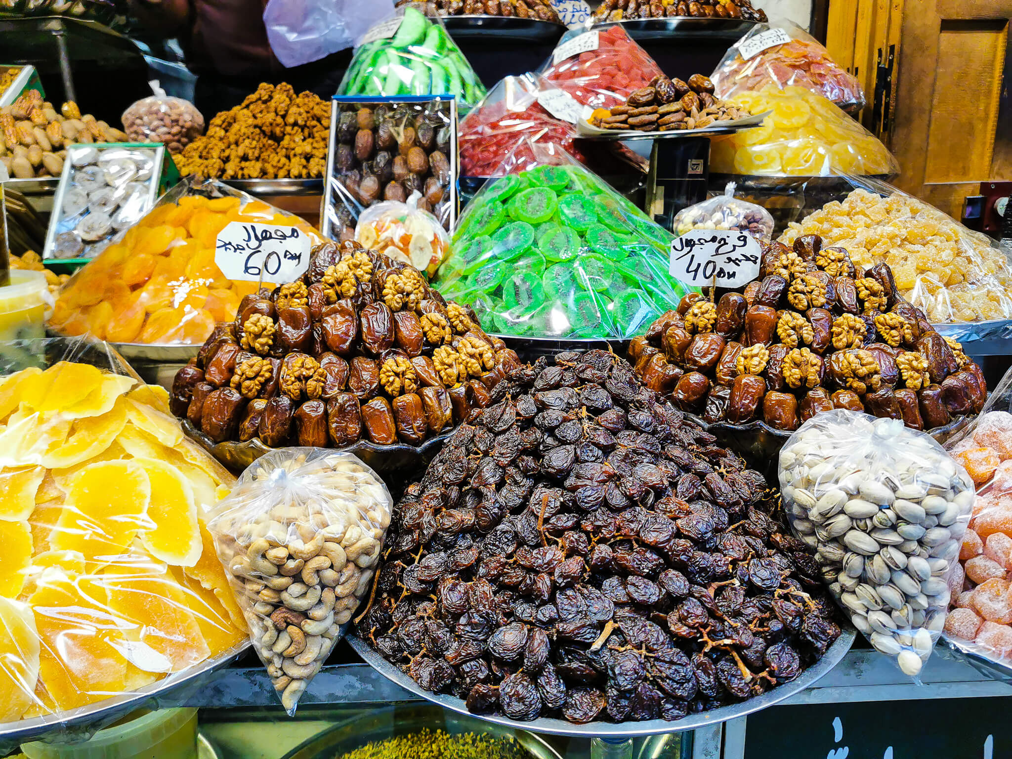 Bunte Vielfalt an getrockneten Früchten, Nüssen und Süßigkeiten auf einem Marktstand.