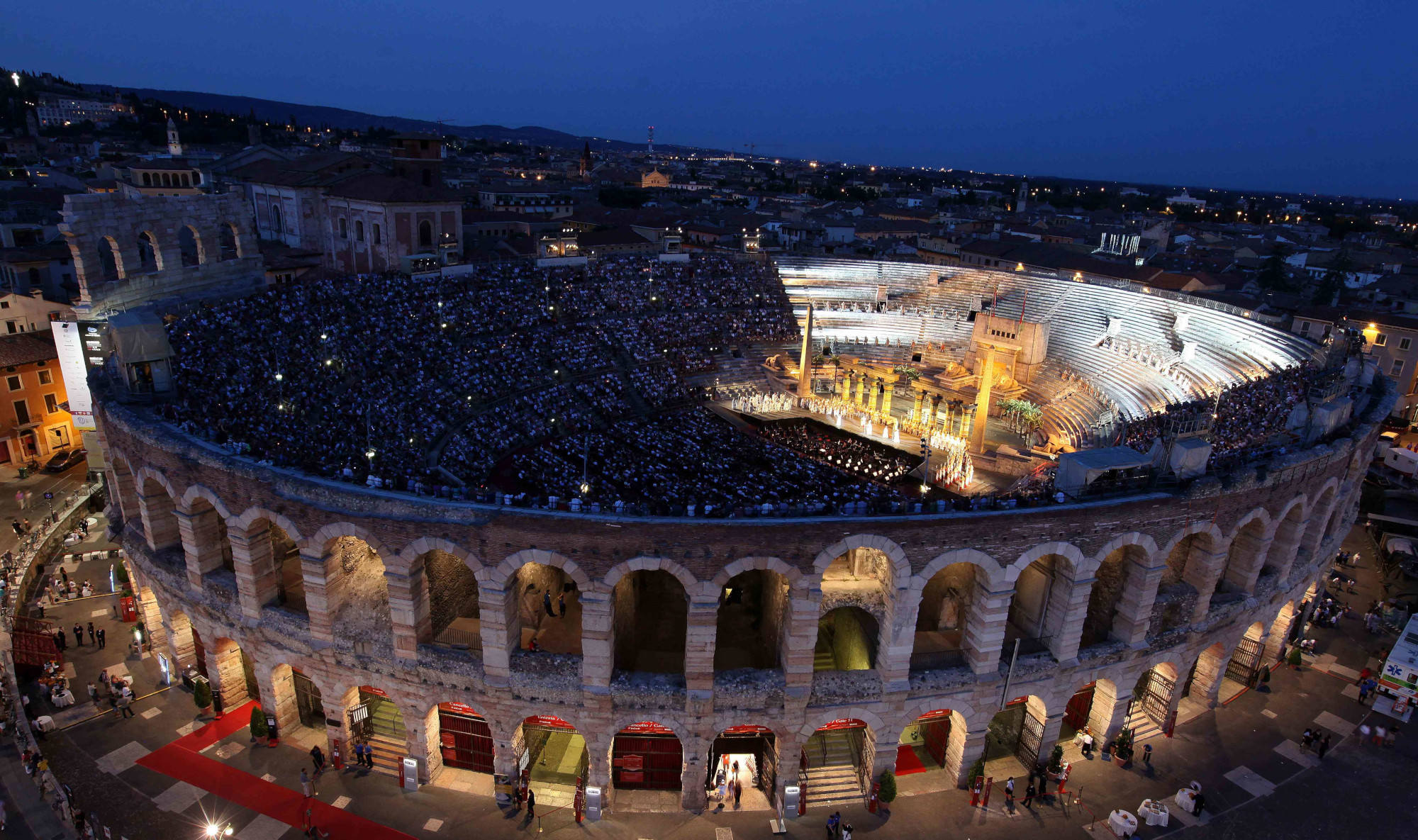 Die Arena von Verona bei Nacht, gefüllt mit Zuschauern, während einer spektakulären Aufführung.