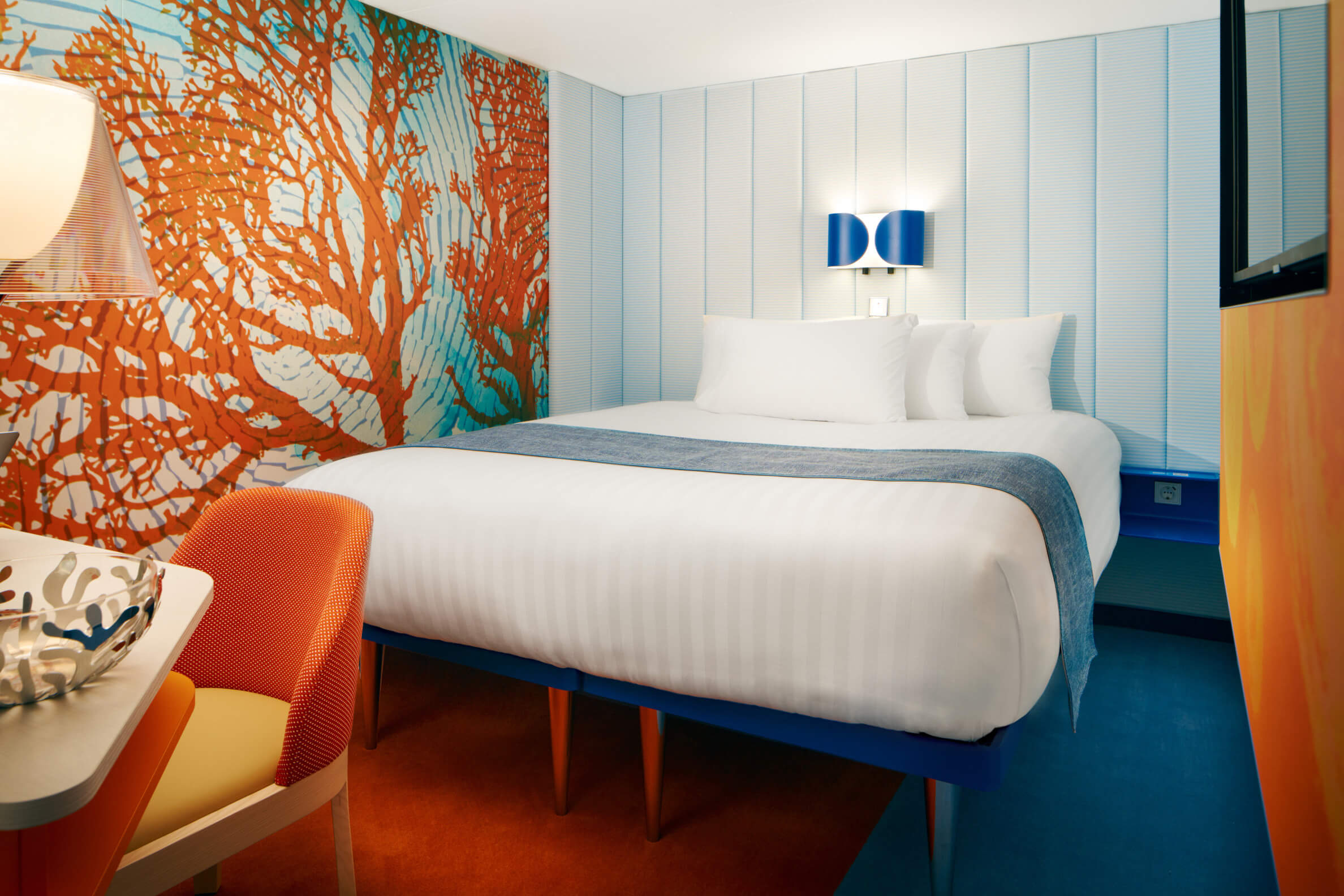 Helles, modernes Zimmer mit einem bequemen Bett und farbenfrohem Design an der Wand. Gemütlich und stilvoll.
