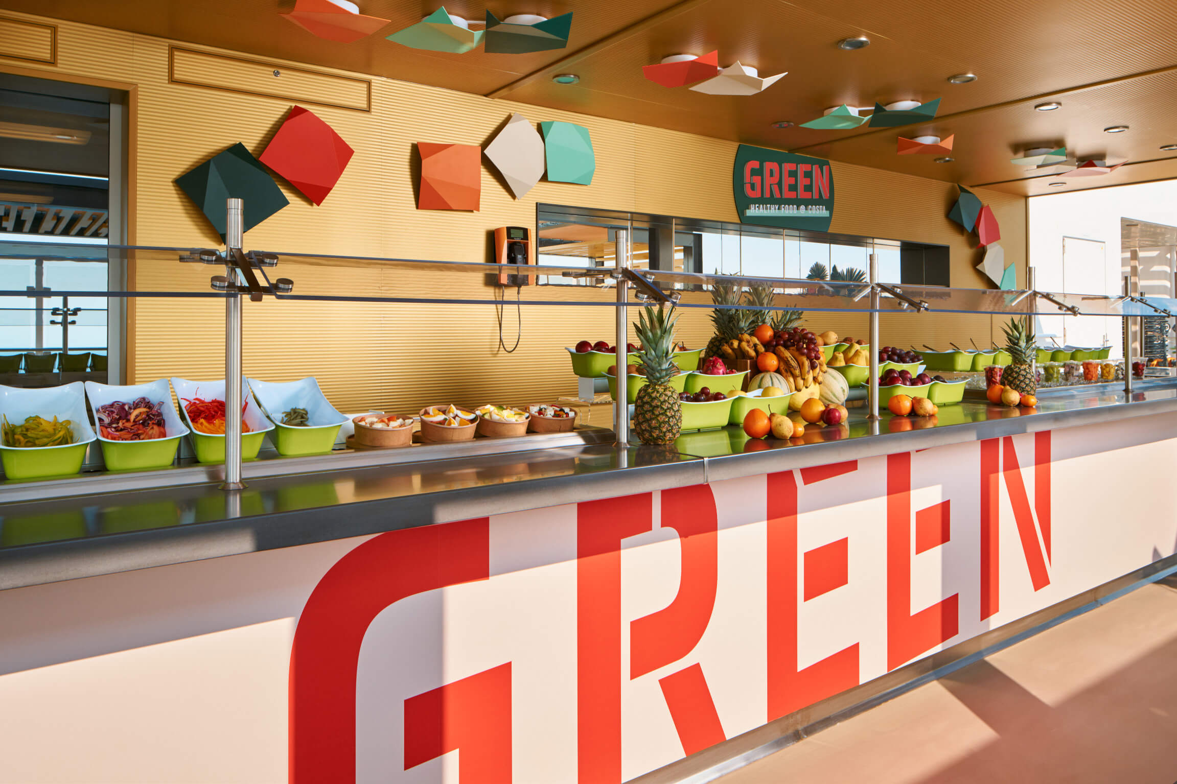Bunte Obst- und Gemüsebar mit frischen Speisen, modernem Design und der Aufschrift „GREEN“.