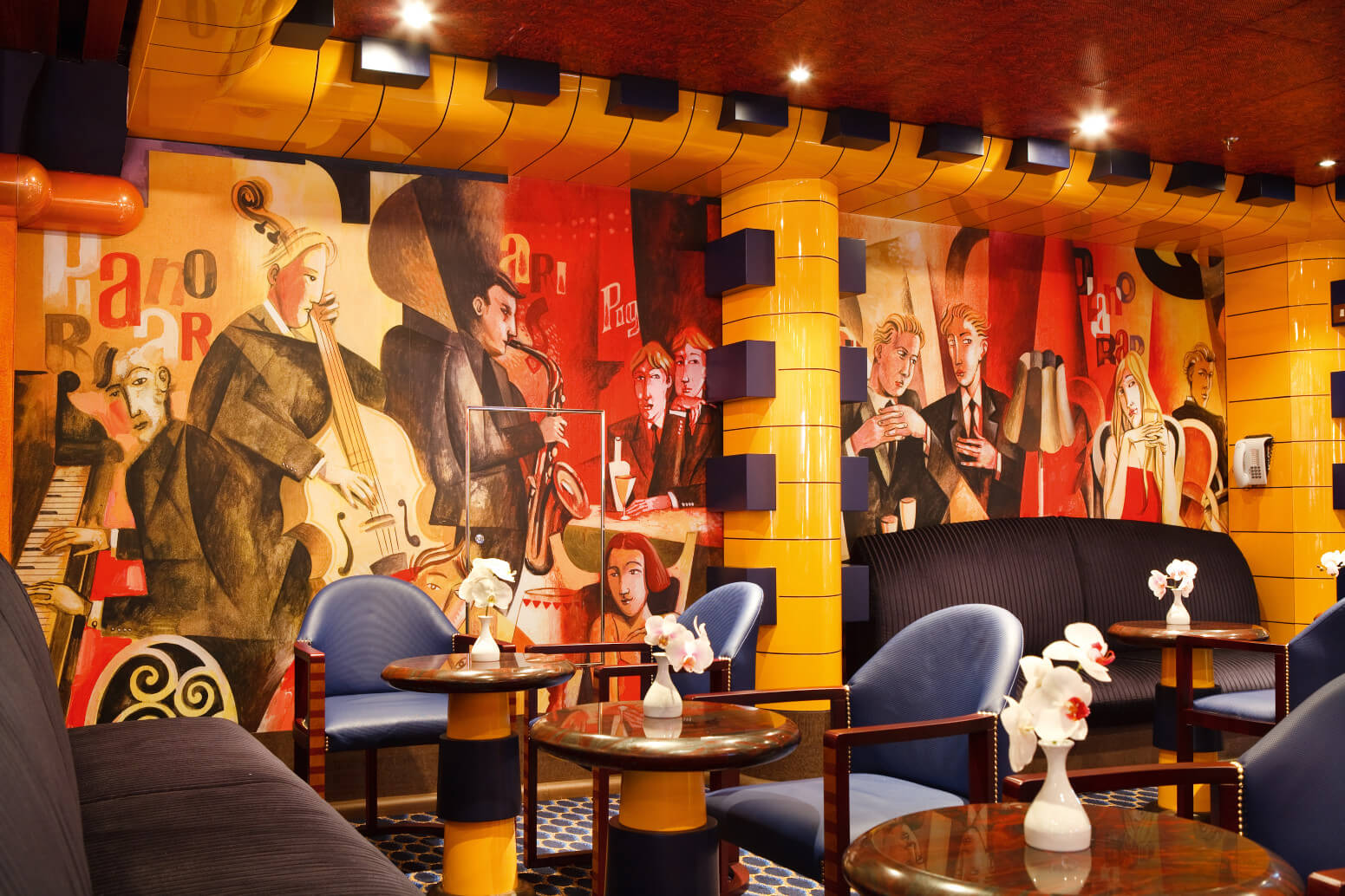 Eine stilvolle Lounge mit bunten Wänden, gemütlichen Sesseln und eleganten Tischen, die live Musik suggeriert.