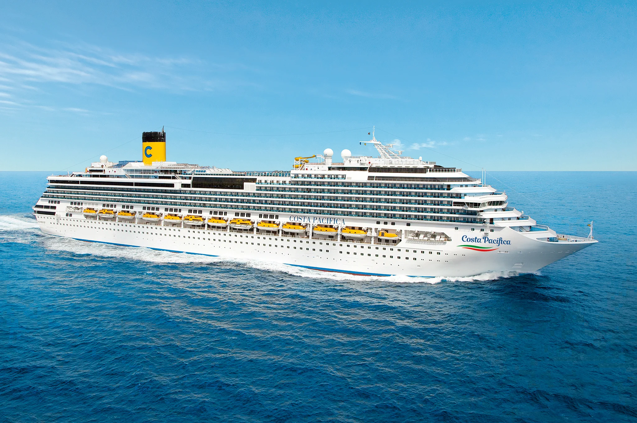 Ein großes Kreuzfahrtschiff, die Costa Pacifica, fährt durch das blaue Wasser unter einem klaren Himmel.