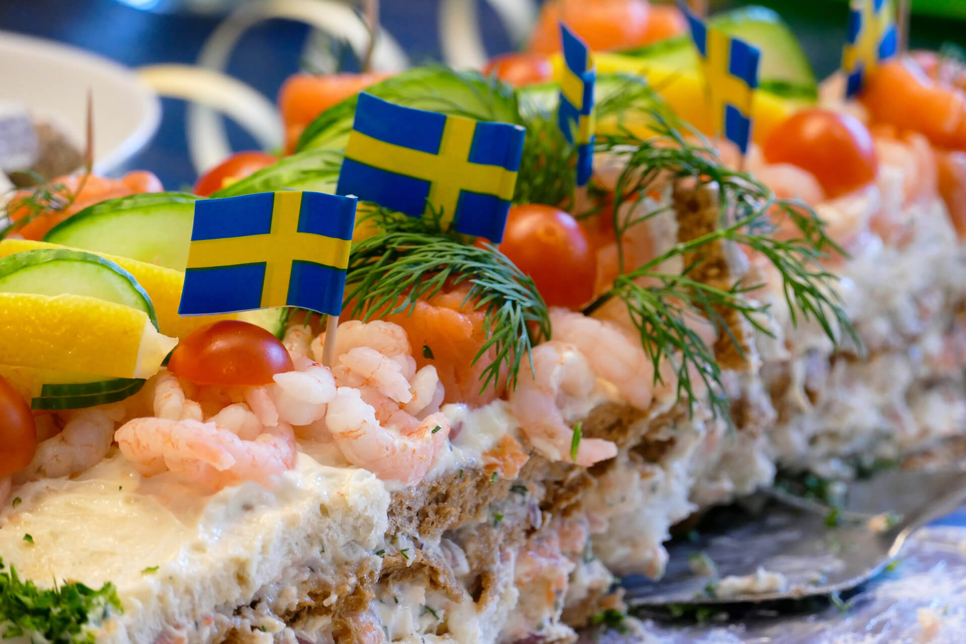 Ein festlicher Krebskuchen mit Garnelen, Tomaten und schwedischen Fähnchen dekoriert. Lecker und einladend!