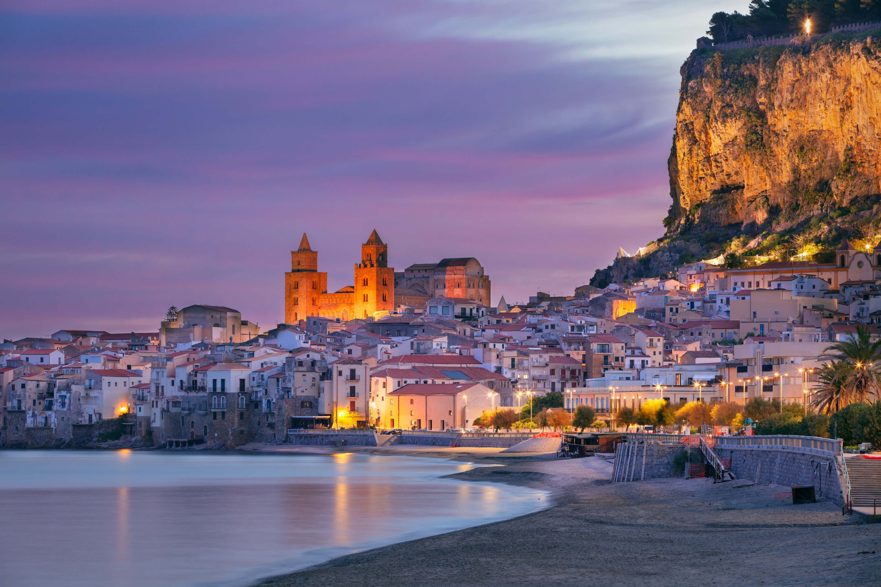 Ein malerischer Küstenort mit historischen Gebäuden und sanften Farben im Sonnenuntergang.