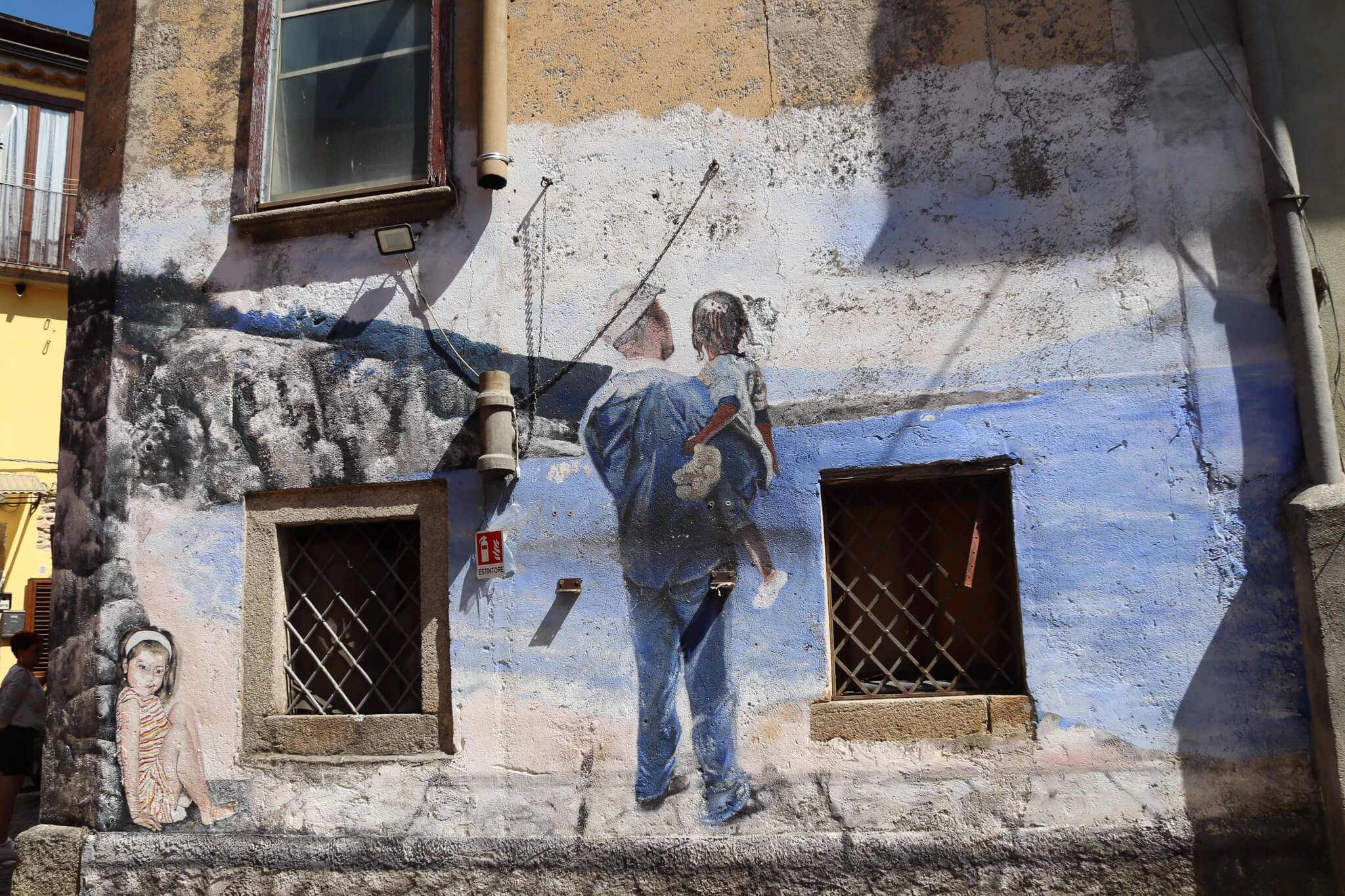 Ein Wandbild zeigt einen Mann mit einem Kind, die zusammen auf das Wasser schauen, umgeben von weiteren grafischen Elementen.