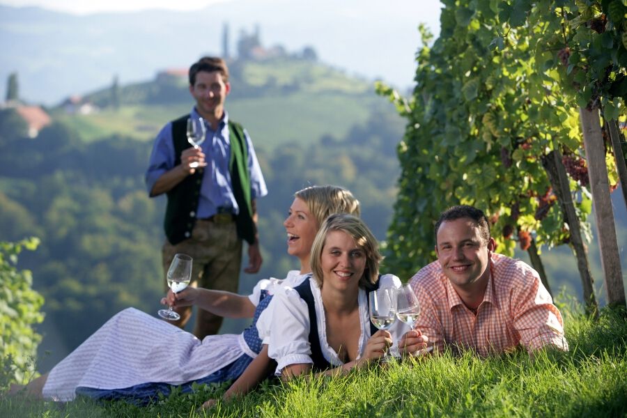 Freunde genießen einen fröhlichen Moment in den Weinbergen, umgeben von Natur und guter Stimmung. Prost!