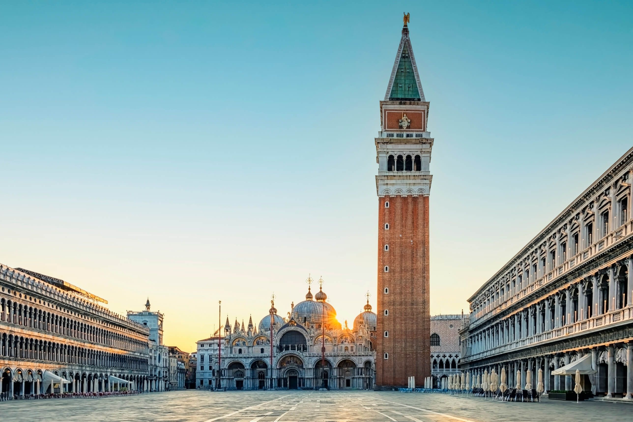 Der Markusplatz in Venedig, mit dem Glockenturm und der Basilika bei Sonnenaufgang.