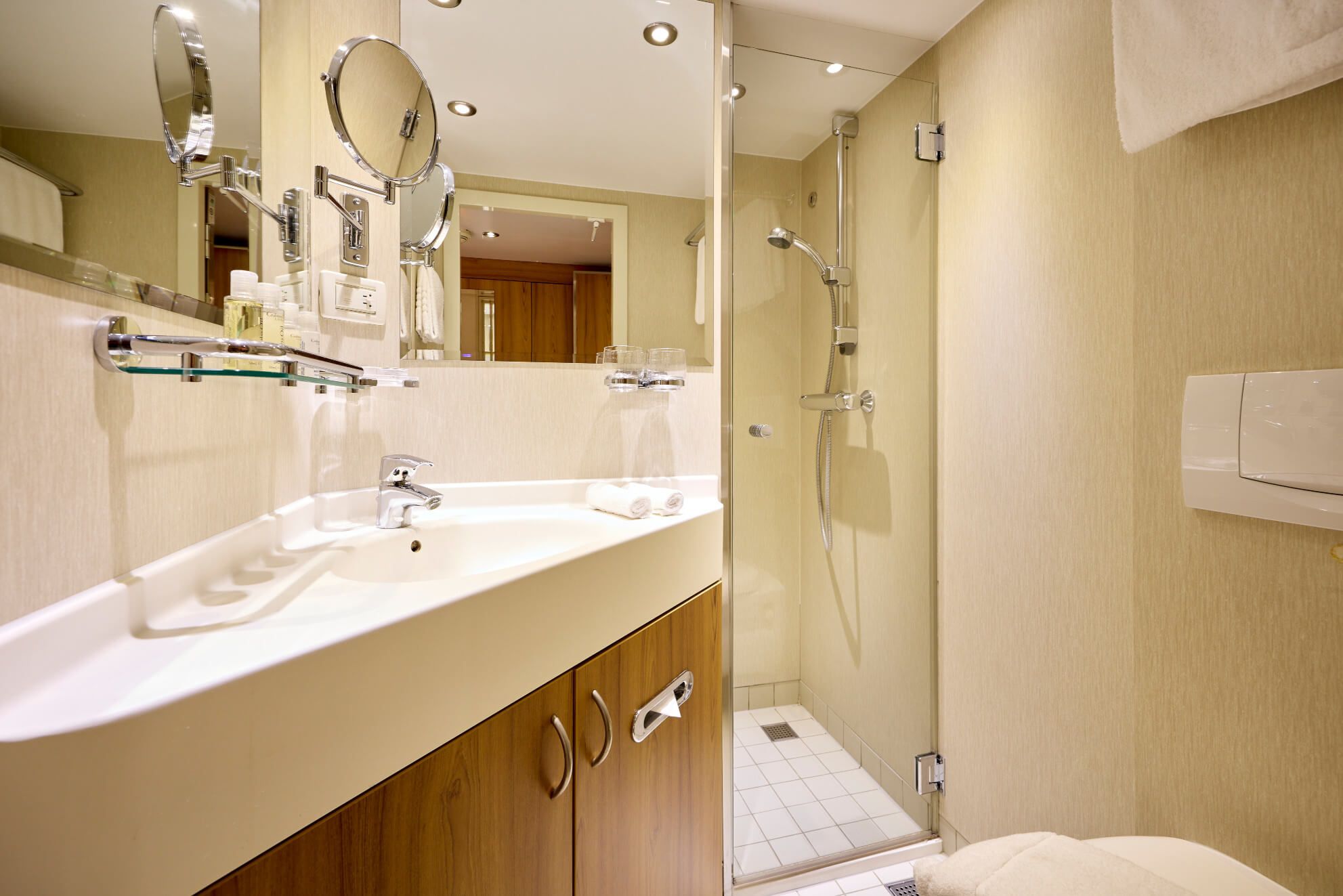 Modernes Badezimmer mit Waschtisch, Spiegel, Dusche und Holzschrank. Helle, elegante Gestaltung.