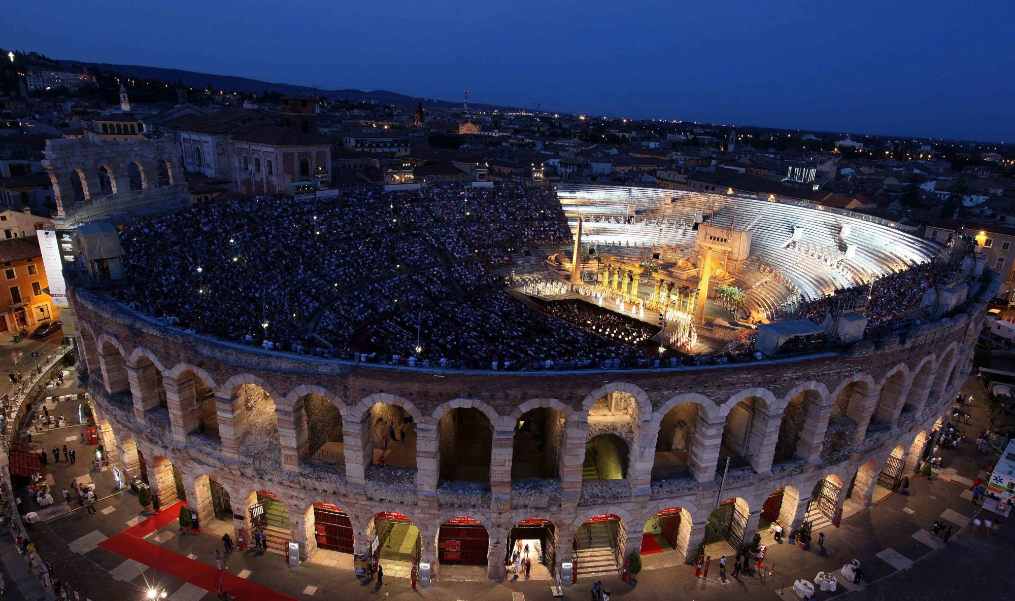 Die Arena von Verona bei Nacht, gefüllt mit Zuschauern, während einer spektakulären Aufführung.