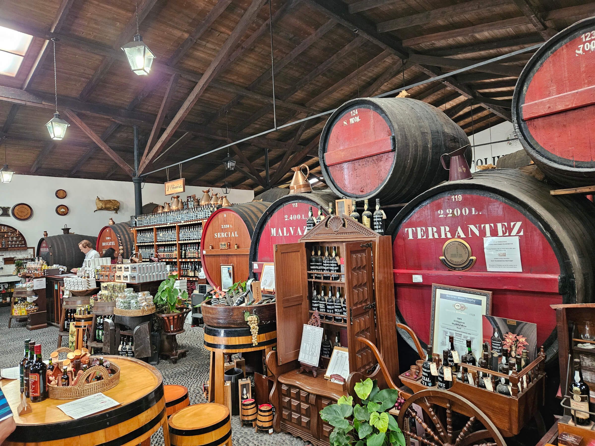 Ein traditioneller Weinkeller mit großen Fässern, Regalen voller Flaschen und rustikalem Ambiente.