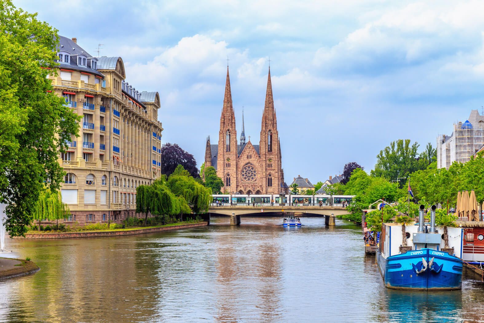 Eine malerische Stadtansicht mit einer Kirche, einem Fluss und grünen Bäumen, die Ruhe ausstrahlt.