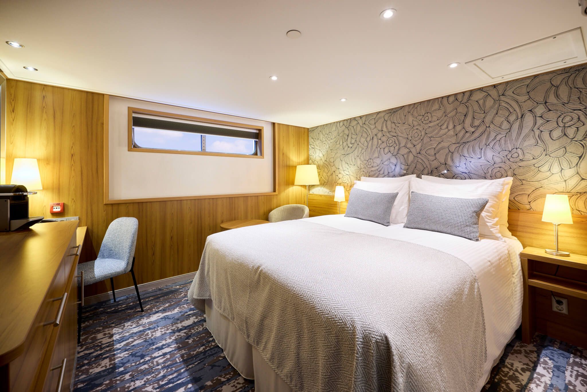 Ein modernes Hotelzimmer mit einem großen Bett, dekorativen Wänden und sanfter Beleuchtung.