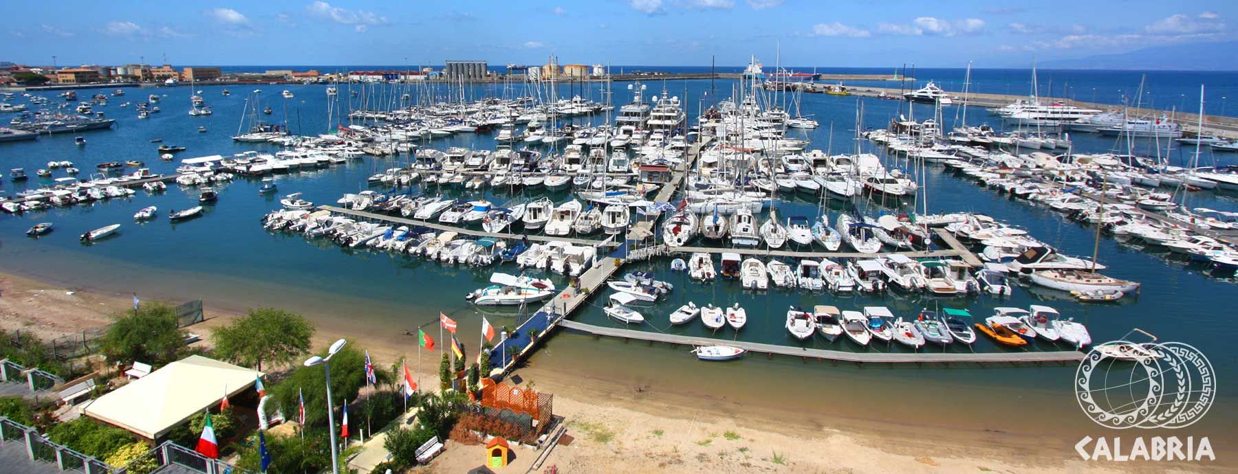 Ein lebhafter Yachthafen mit vielen Booten, ruhigem Wasser und blauer Himmel in Calabria.