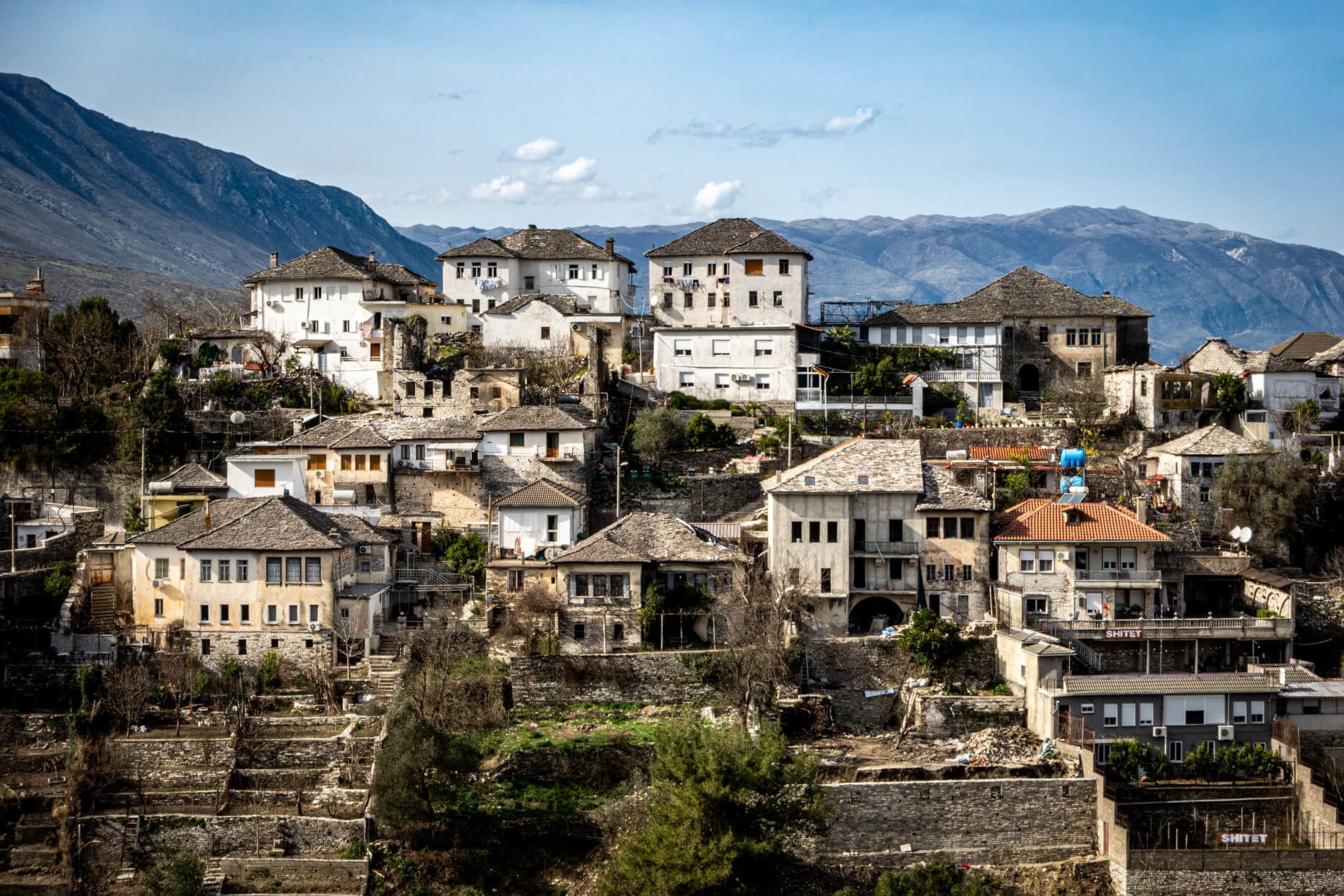 Eine Hügelstadt mit historischen Gebäuden und beeindruckender Landschaft im Hintergrund.